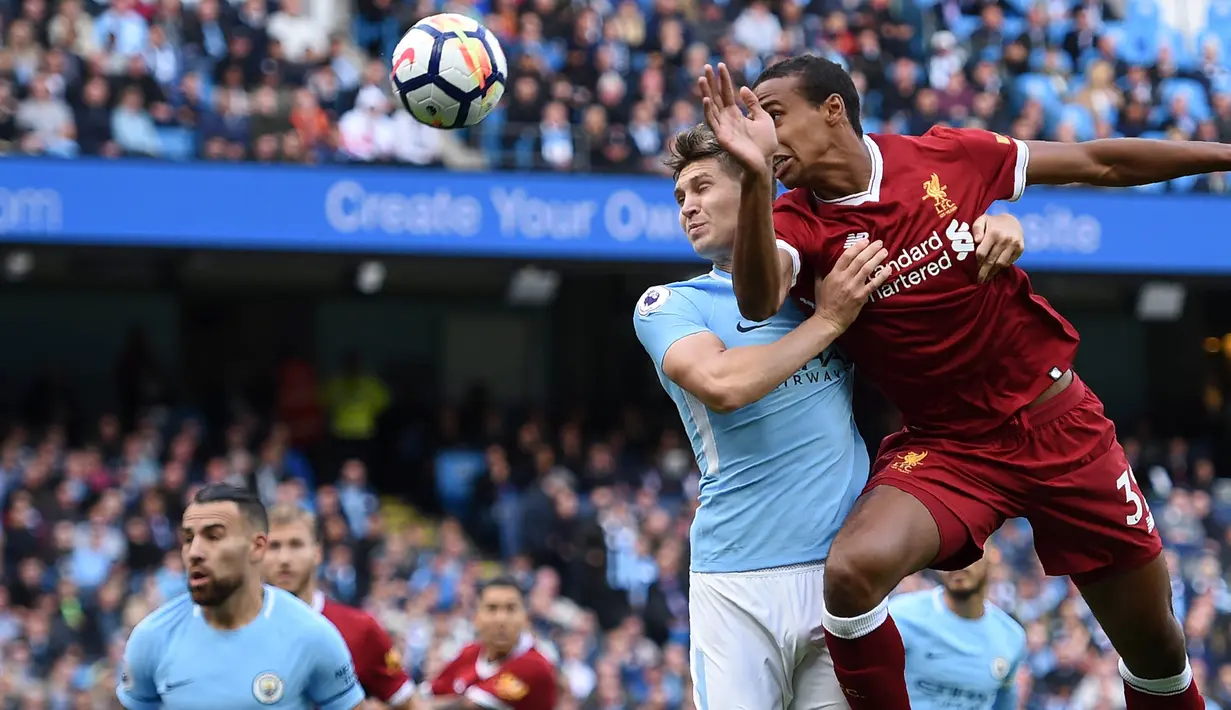 Bek Liverpool, Joel Matip, duel udara dengan bek Manchester City, John Stones, pada laga Premier League di Stadion Ettihad, Manchester, Sabtu (9/9/2017). City menang 5-0 atas Liverpool. (AFP/Oli Scarff)
