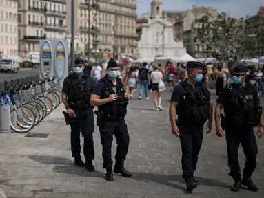Polisi anti huru-hara Prancis mengamati warga yang mengenakan masker di Marseille, Selasa (18/8/2020). Pemerintah Prancis mengirim polisi anti huru hara ke wilayah Marseille untuk membantu menegakkan peraturan penggunaan masker saat negara itu mencatat lonjakan kasus COVID-19. (AP Photo/Daniel Cole)