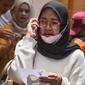 Seorang wanita melakukan panggilan telepon sambil memegang foto korban kerusuhan Stadion Kanjuruhan menangis saat menunggu di Rumah Sakit Saiful Anwar, Malang, Jawa Timur, Minggu (2/10/2022). Hingga saat ini, dilaporkan sebanyak 129 orang meninggal dunia dalam kejadian tersebut. (AP Photo/Trisnadi)
