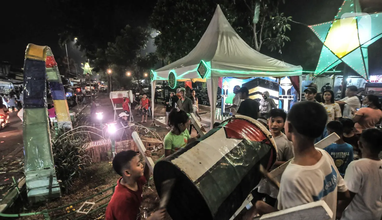 Anak-anak memainkan bedug saat merayakan malam takbiran Idul Fitri di Manggarai, Jakarta, Rabu (13/5/2021). Tradisi merayakan malam takbiran dengan memainkan bedug dan membuat hiasan bernuansa Islam masih terlihat di pinggiran Ibu Kota meski pandemi Covid-19. (merdeka.com/Iqbal S. Nugroho)