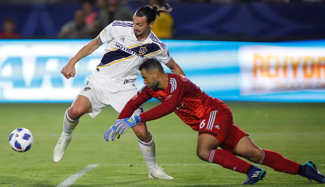 Penyerang LA Galaxy, Zlatan Ibrahimovic menggiring bola melewati kiper Orlando City, Earl Edwards Jr pada pertandingan MLS di StubHub Center di Carson, California (29/7). Ibrahimovic mencetak hattrick dipertandingan ini. (AFP Photo/Katharine Lotze)
