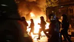 Petugas kepolisian melewati api yang dinyalakan oleh demonstran saat berunjuk rasa di Hamburg, Kamis (6/7). Polisi antihuru-hara Jerman bentrok dengan para pengunjuk rasa menjelang pertemuan puncak KTT G20 yang digelar pada 7-8 Juli. (AP/Markus Schreiber)