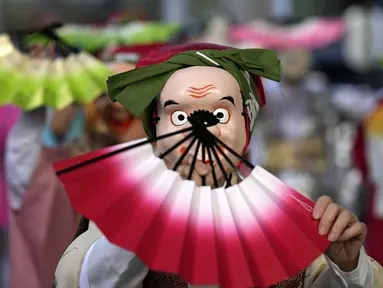 Seniman yang mengenakan topeng badut tradisional Jepang tampil selama Festival Konpira di kuil Kotohiragu di distrik bisnis Toranomon, Tokyo, Selasa (10/1/2023). Festival Konpira pertama di tahun 2023 ini dimeriahkan dengan penampilan para seniman yang mengenakan topeng tradisional Jepang. (AP Photo/Eugene Hoshiko)
