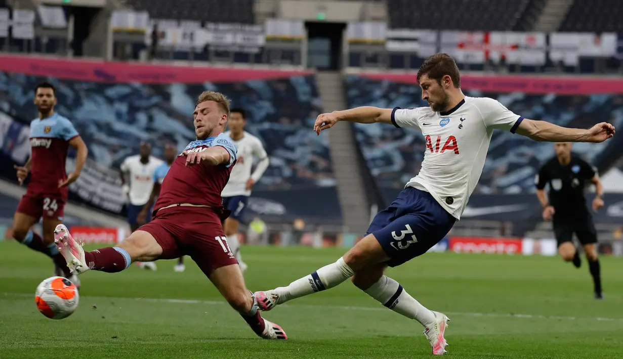 Bek Tottenham Hotspur, Welsh Ben Davie mengumpan bola dari kawalan striker West Ham, Jarrod Bowen pada pertandingan lanjutan Liga Inggris di Stadion Tottenham Hotspur di London (23/6/2020). Tottenham menang 2-0 atas West Ham. (AFP/Pool/Kirsty Wigglesworth)