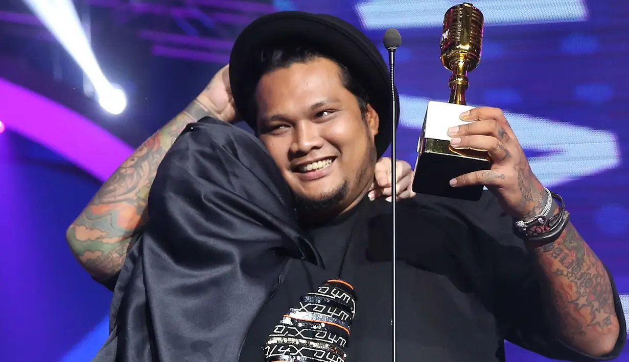 Di atas panggung, menerima piala kemenangannya itu Virgoun mengajak sang istri, Innara yang kini telah berhijab. Tampak keduanya berpelukan di atas panggung megah tersebut. (Bambang E.Ros/Bintang.com)