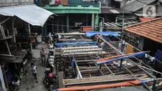Aktivitas perajin tempe saat mogok produksi di kawasan Sunter Jaya, Jakarta Utara, Senin (21/2/2022). Mulai hari ini perajin tempe dan tahu se-Pulau Jawa mogok produksi selama tiga hari ke depan sebagai respon mahalnya harga kedelai yang mencapai Rp11.000 per kg. (merdeka.com/Iqbal S. Nugroho)