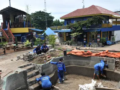 Petugas dari Dinas Sumber Daya Air (SDA) Bidang Aliran Tengah saat menyelesaikan pembangunan Taman Robika di Pintu Air Manggarai, Jakarta, Kamis (14/3). (merdeka.com/Iqbal S. Nugroho)