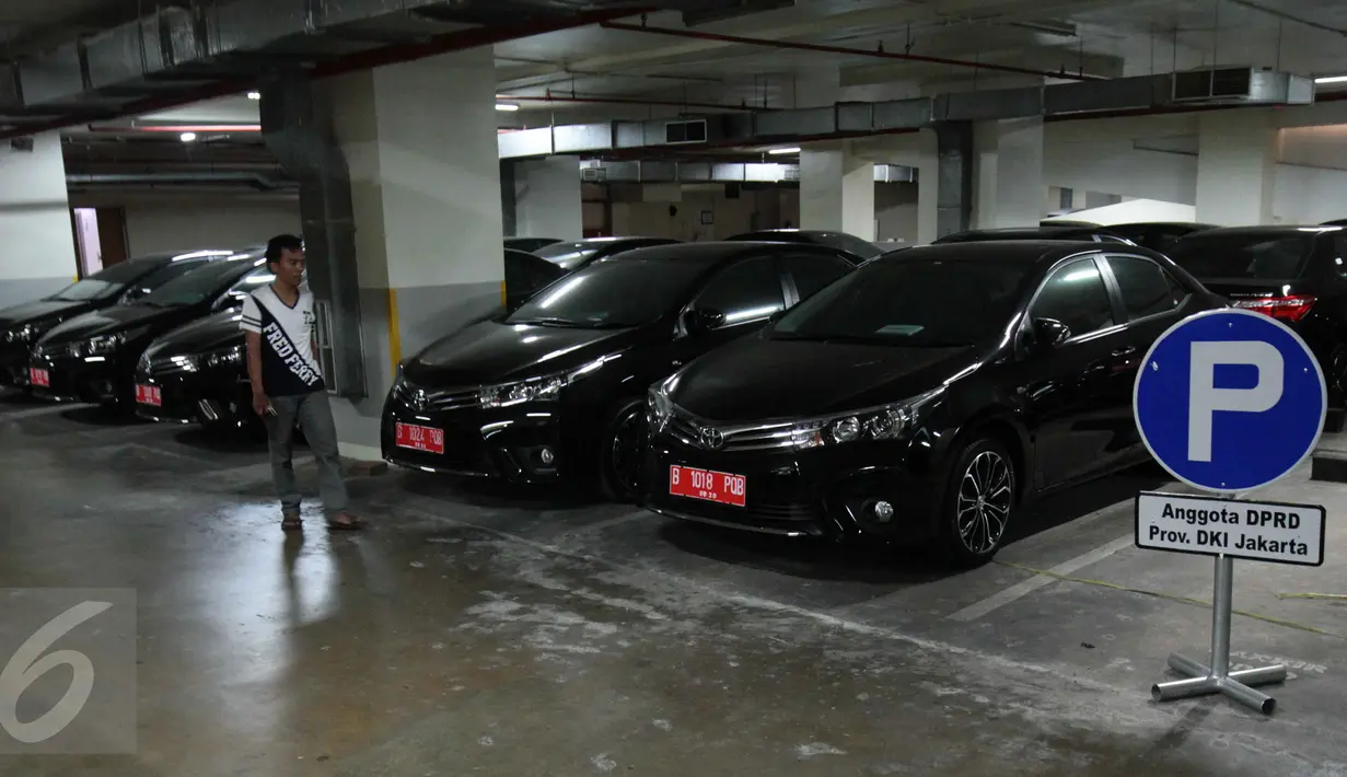 Seorang pria berjalan di dekat mobil sedan Toyota Corolla Altis di basement Gedung DPRD DKI Jakarta, Kamis (3/9). Mobil tersebut dibelikan Gubernur Basuki ‘Ahok’ Tjahaja Purnama untuk 101 anggota DPRD DKI periode 2014-2019. (Liputan6.com/Gempur M Surya)