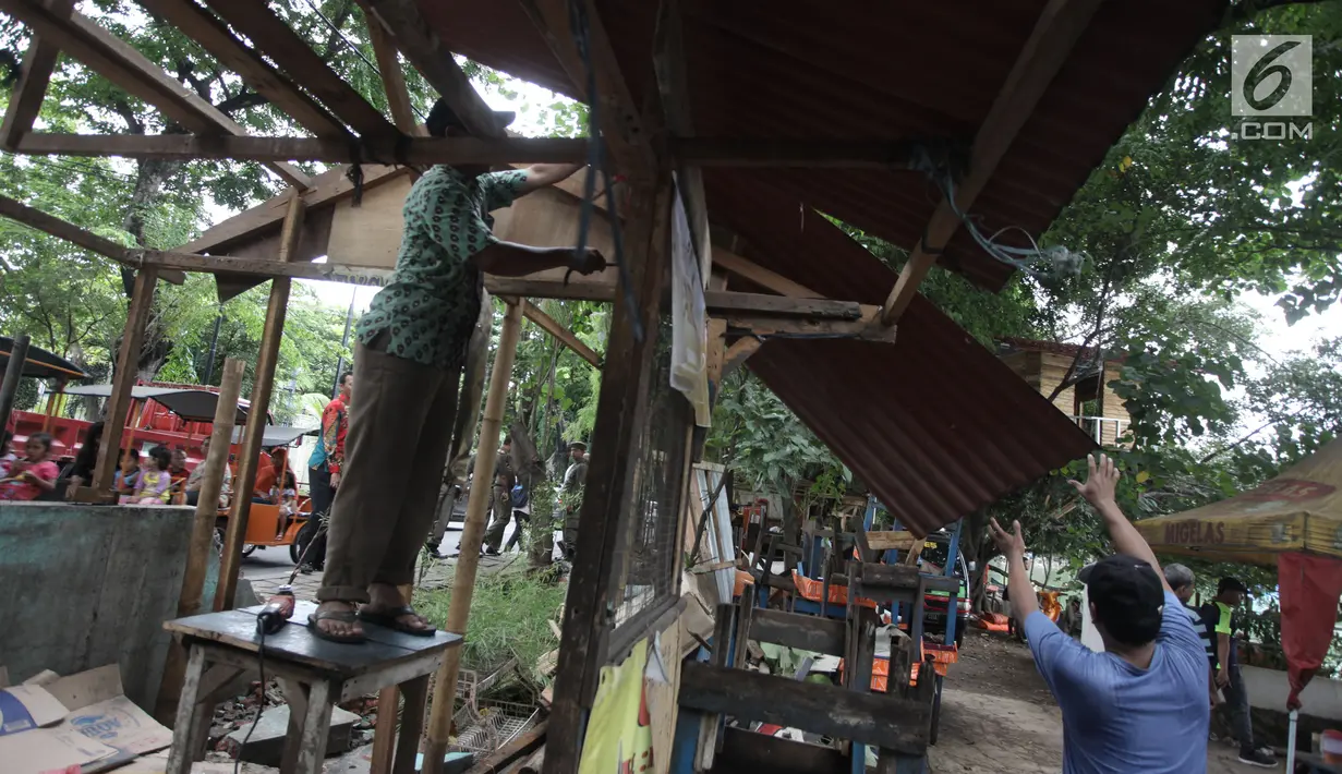 Pedagang membongkar sendiri lapaknya di kawasan Danau Sunter, Jakarta Utara, Jumat (19/1). Selain mempercantik estetika, penataan dilakukan untuk mendukung pelaksanaan Festival Danau Sunter pada Februari 2018. (Liputan6.com/Arya Manggala)