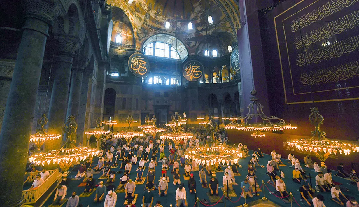 Jemaah mengenakan masker dan menerapkan jaga jarak untuk menghindari penularan COVID-19 saat melaksanakan salat Idul Adha di Hagia Sophia, Istanbul, Turki, Jumat (31/7/2020). Ini merupakan salat Idul Adha pertama di Hagia Sophia setelah dialihfungsikan dari museum menjadi masjid. (Pool via AP)
