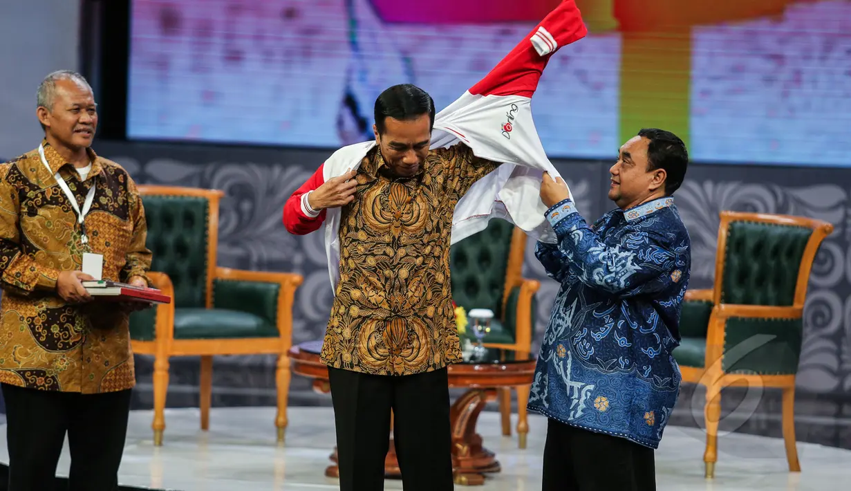 Presiden Joko Widodo mendapatkan jaket spesial saat menghadiri Silatuhrahmi Pers Nasional di gedung Auditorium  TVRI, Jakarta, Senin (27/4/2015). Tampak Jokowi mengenakan jaket berwarna merah putih pemberian Ketua PWI Margiono (Liputan6.com/Faizal Fanani)