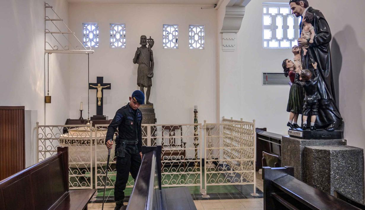 Misa Natal diartikan sebagai perayaan atau ibadah utama dalam kalender Gereja Kristiani, khususnya Umat Katolik. Kegiatan ini bertujuan memperingati kelahiran Yesus Kristus. Tampak dalam foto, personel dari unit Gegana dan Jihandak Brimob Polda Jawa Timur melakukan pemeriksaan di dalam area Gereja Katedral Hati Kudus Yesus, atau yang dikenal secara lokal sebagai gereja "Hati Kudus Yesus", Surabaya, pada Rabu 24 Desember 2025. (JUNI KRISWANTO/AFP)