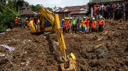 Tim pencari dan penyelamat gabungan terus melakukan upaya pencarian terhadap sejumlah warga yang dilaporkan hilang. Tampak dalam foto, petugas penyelamat berkumpul di sekitar ekskavator selama operasi pencarian korban di lokasi longsor di Desa Situkung, Banjarnegara, Jawa Tengah, pada Kamis 20 November 2025. (DEVI RAHMAN/AFP)