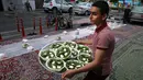 Seorang relawan menyiapkan makanan berbuka di sebuah jalan di Teheran, 29 Mei 2018. Sebagian besar warga muslim Iran melaksanakan ibadah puasa di bulan Ramadan sesuai ajaran Islam melalui Nabi Muhammad. (AP Photo/Vahid Salemi)