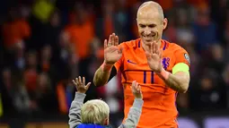 Gelandang Belanda, Arjen Robben bersama anaknya usai pertandingan melawan Swedia pada kualifikasi Piala Dunia 2018 di stadion Arena, Amsterdam (10/10). Dua gol yang dicetak Robben gagal mengantar Der Oranje lolos. (AFP Photo/Emmanuel Dunand)