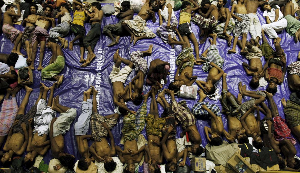 Dengan beralaskan terpal para pengungsi tidur di tempat penampungan, Lhoksukon, Aceh, Senin (11/5/2015). Sekitar 500 migran terdampar di pantai Aceh setelah terapung-apung di laut selama sebulan karena kehabisan bahan bakar. (REUTERS/Roni Bintang)