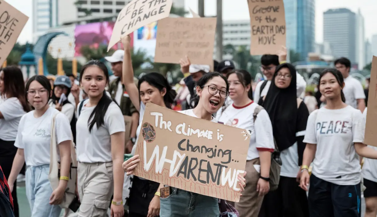 Para peserta memegang plakat saat mereka berbaris di jalan menjelang Hari Bumi pada 22 April, hari kesadaran lingkungan tahunan, di Jakarta pada 21 April 2024. (Yasuyoshi CHIBA/AFP)