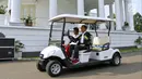 Presiden Joko Widodo atau Jokowi dan sprinter Lalu Muhammad Zohri menaiki mobil golf di Istana Bogor, Jawa Barat, Rabu (18/7). Jokowi tampak mengenakan jaket Asian Games saat menerima kedatangan Zohri. (Liputan6.com/Pool/Biro Pers Setpres)