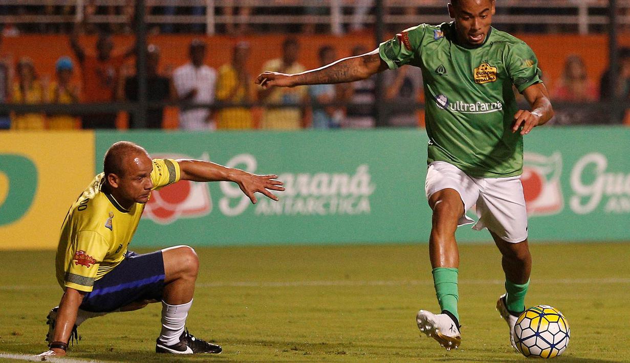 Gelandang Brasil, Gabriel Jesus, berusaha melewati Leo pada laga amal. Pertandingan amal yang diikuti sejumlah atlet Brasil ini dilakukan untuk mengenang para pemain Chapecoense yang menjadi korban kecelakaan pesawat. (Reuters/Leonardo Benassatto)