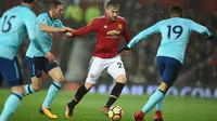 Pemain Manchester United Luke Shaw berebut bola dengan pemain AFC Bournemouth, Junior Stanislas pada lanjutan laga Premier League di Old Trafford, Rabu (13/12). Romelu Lukaku menjadi penentu kemenangan dengan skor 1-0 itu. (Oli SCARFF / AFP)