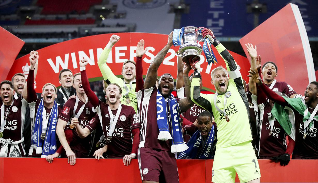 Kiper Leicester City, Kasper Schmeichel dan Wes Morgan mengangkat trofi usai menjuarai Piala FA di Stadion Wembley, Sabtu (15/5/2021). The Foxes menang dengan skor 1-0. (Nick Potts/Pool via AP)