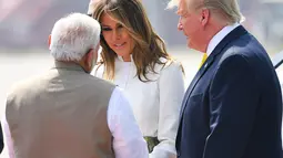 PM India, Narendra Modi berbincang dengan Ibu Negara Melania Trump disaksikan Presiden AS Donald Trump setibanya di Bandara Internasional Sardar Vallabhbhai Patel di Ahmedabad, Senin (24/2/2020). Donald Trump mendarat di India dan resmi memulai kunjungan kenegaraan. (MANDEL NGAN/AFP)