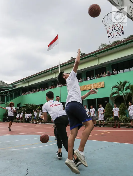 Siswa memasukan bola basket pada program coaching clinic dan NBA Cares yang digelar Jr. NBA Indonesia di SMAN 82 Jakarta, Kamis (28/9).The NBA kembali menggelar program Jr. NBA, bagi pengembangan generasi muda bertaraf global yang mempromosikan gaya hidup sehat dan aktif. (Liputan6.com/Fery Pradolo)