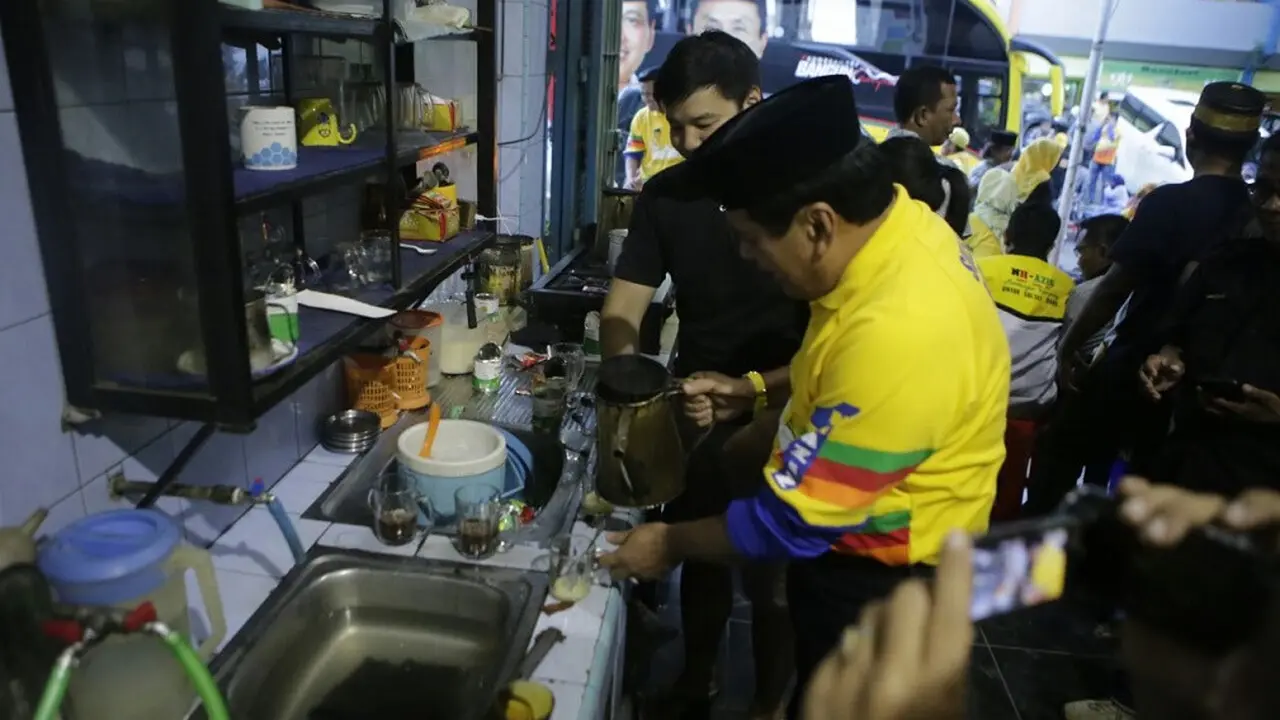 Cagub Sulsel, Nurdin Halid berlagak sebagai peracik kopi melayani pengunjung salah satu warkop di Kabupaten Soppeng, Sulsel (Liputan6.com/ Eka Hakim)