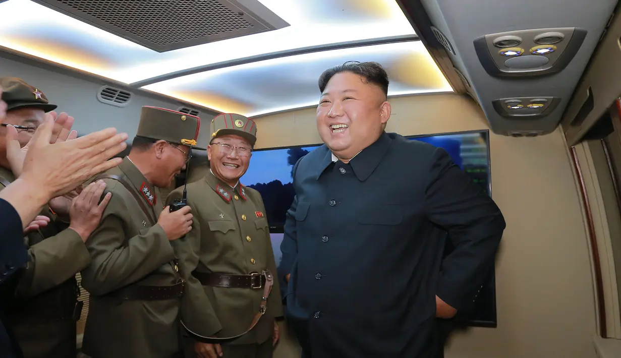Pemimpin Korut Kim Jong-Un tersenyum setelah mengamati tembakan dua rudal taktis terbaru di lokasi bagian barat yang dirahasiakan (7/8/2019). Peluncuran rudal terbaru negaranya, adalah peringatan keras bagi Washington dan Seoul atas rencana latihan militer kedua negara. (KCNA VIA KNS/AFP)