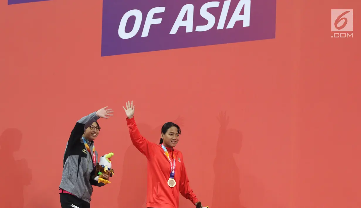 Syuci Indriani (kanan) usai prosesi medali usai laga final 200 meter gaya bebas putri S14 Asian Para Games 2018 di Stadion Akuatik Kompleks GBK, Minggu (7/10). Syuci meraih perunggu dengan waktu 2 menit 20,80 detik. (Liputan6.com/Helmi Fithriansyah)