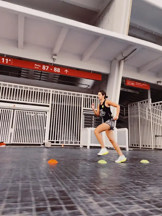 Mengenakan celana pendek abu-abu dan kaus hitam tanpa lengan plus sneakers dengan bantalan tebal, Nia Ramadhani berlari di Gelora Bung Karno alias GBK Jakarta. “Keep on learning #run (Terus belajar #lari),” cuit bintang film Hantu Jembatan Ancol bersama foto itu. Salah satu putra Nia Ramadhani tampak menemani di foto lain. (Foto: Dok. Instagram @ramadhaniabakrie)