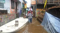 Seorang warga menggendong anaknya melewati banjir di kawasan Kampung Pulo, Jatinegara, Jakarta Timur, Selasa (10/2/2015). Warga tetap beraktivitas meski harus menembus banjir yang melanda pemukiman mereka. (Liputan6.com/Herman Zakharia)