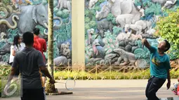 Warga berolahraga bulutangkis di sekitar kawasan Kebun Binatang Ragunan, Jakarta, Minggu (9/10). Kawasan KBR menjadi salah satu lokasi alternatif warga Jakarta untuk berolahraga pada Minggu pagi. (Liputan6.com/Helmi Fithriansyah)