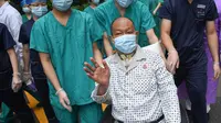 Petugas medis mendampingi Cui saat meninggalkan Rumah Sakit Renmin Universitas Wuhan di Wuhan, Provinsi Hubei, China (21/7/2020). Cui, seorang pasien COVID-19 yang menjalani operasi transplantasi paru-paru ganda, sembuh setelah perawatan selama berbulan-bulan dan dipulangkan. (Xinhua/Cheng Min)