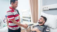 Pelatih Persebaya, Djadjang Nurdjaman, menjenguk Robertino Pugliara seusai operasi di Rumah Sakit Orthopedi dan Traumatologi, Surabaya, Selasa (16/10/2018).. (Bola.com/Dok. Persebaya)