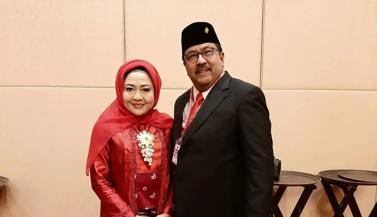 Dampingi suami bertugas, Dewi tampil anggun kenakan kebaya kutubaru merah sederhana yang dipadukan dengan angkin dan hijab warna senada. [@dewiranokarno].