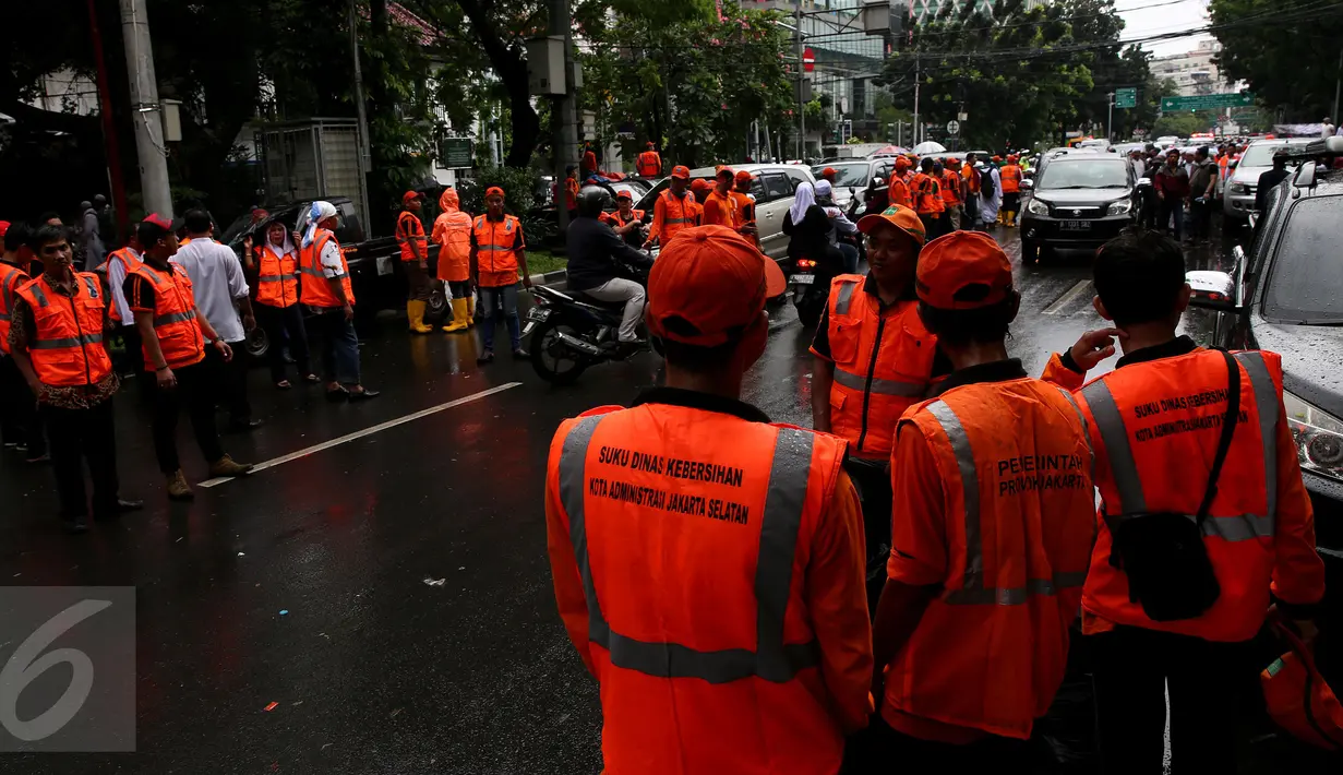 Pasukan oranye (petugas kebersihan) disiagakan membersihkan kawasan Monas, Jakarta, saat berlangsungnya aksi damai 2 Desember, Jumat (2/12). Pasukan oranye dibekali kantong plastik besar untuk memungut sampah yang berserakan. (Liputan6.com/Johan Tallo)