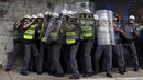 Polisi Anti Huru hara melindungi diri di balik perisai saat diserang para demonstran, Brasil, Jumat (8/1/2016). Pengunjuk rasa protes terhadap kenaikan tarif untuk bus kota di Sao Paulo. (Reuters/Nacho Doce)