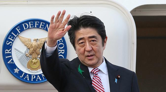 Dalam file foto pada 21 April 2015, Shinzo Abe yang masih menjabat sebagai Perdana Menteri Jepang melambai saat berangkat menuju Indonesia di Bandara Internasional Tokyo di Tokyo. Shinzo Abe dikabarkan telah meninggal dunia, setelah menjalani perawatan beberapa saat akibat akibat penembakan di Nara pada Jumat, 8 Juli 2022. (JIJI PRESS / AFP)