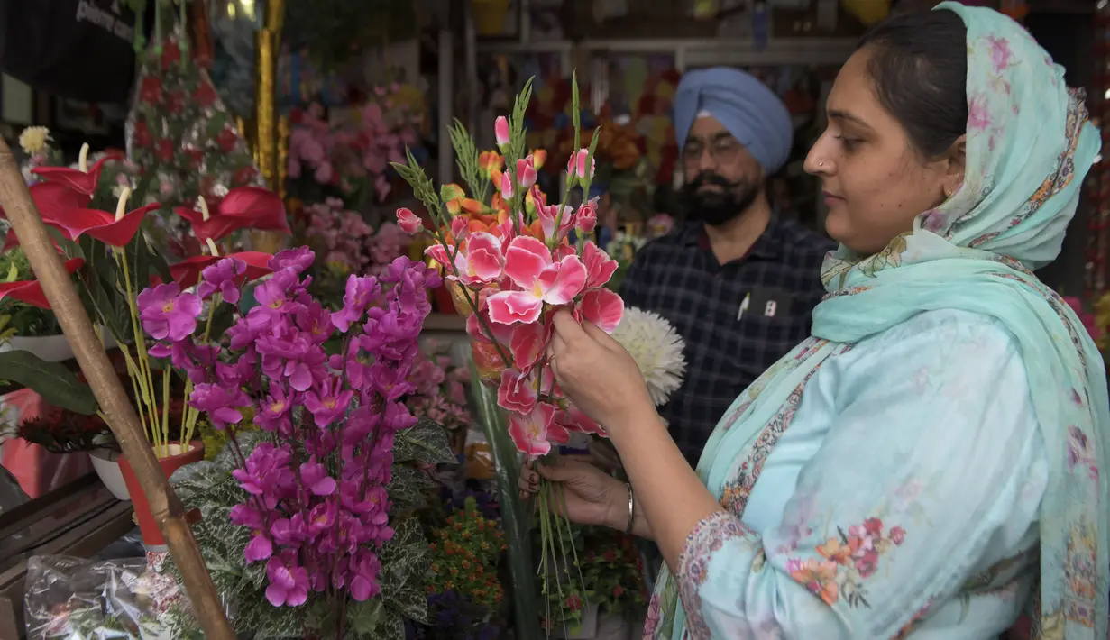 Seorang perempuan membeli bunga palsu menjelang festival Diwali di sebuah pasar di Amritsar, India pada 10 November 2020. Tahun ini festival lampu Diwali jatuh pada 14 November mendatang. (Photo by NARINDER NANU / AFP)