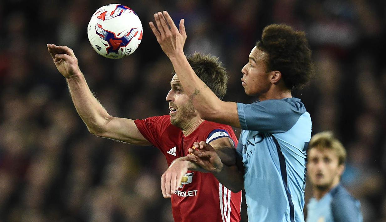 Gelandang Manchester United, Michael Carrick duel udara dengan gelandang Manchester City, Leroy Sane, pada laga Piala Liga di Stadion Old Trafford, Inggris, Rabu (26/10/2016). MU menang 1-0 atas City. (AFP/Oli Scarff)