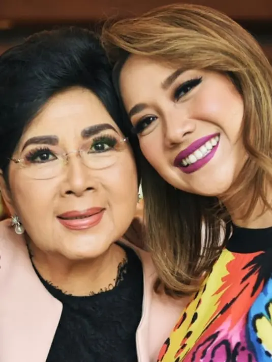 Bunga Citra Lestari mengunggah potret bersama Titiek Puspa yang mengenakan baju hitam dengan outer pink. Sementara itu, BCL mengenakan baju colorfull serta lipstik ungu mattenya. [@itmebcl]