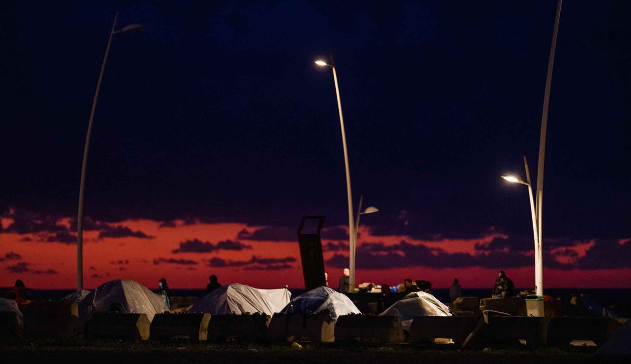 Para pengungsi berjalan di dekat tenda-tenda yang didirikan di sepanjang kawasan tepi laut Beirut, Lebanon, pada Senin 30 Maret 2026. Jumlah pengungsi di Lebanon akibat serangan militer Israel terus meningkat secara signifikan. (Dimitar DILKOFF/AFP)