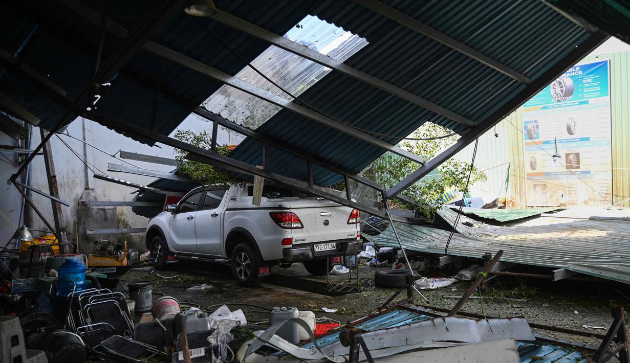 Dengan membawa angin kencang berkecepatan hingga 183 km/jam, terjangan Topan Kalmaegi menyebabkan kerusakan yang cukup luas, pemadaman listrik massal, serta hujan lebat yang memicu banjir. Tampak dalam foto, sebuah kendaraan tertimpa struktur atap yang runtuh di kawasan pesisir Quy Nhon, Provinsi Gia Lai, Vietnam Tengah, pada Jumat 7 November 2025. (NHAC NGUYEN/AFP)