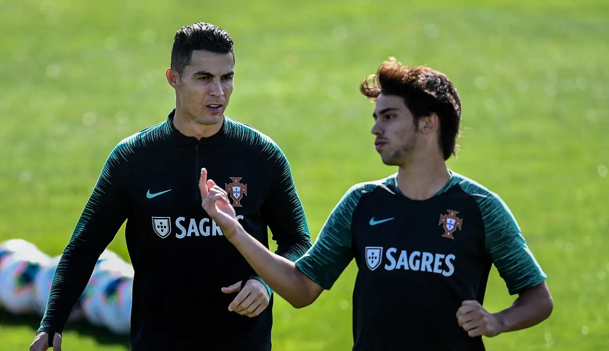 Penyerang Portugal Cristiano Ronaldo (kiri) berbincang dengan Joao Felix saat latihan bersama jelang menghadapi Luksemburg pada laga kualifikasi Euro 2020 di Oeiras, Portugal, Rabu (9/10/2019). Portugal akan menghadapi Luksemburg pada 12 Oktober 2019. (Patricia De Melo Moreira/AFP)