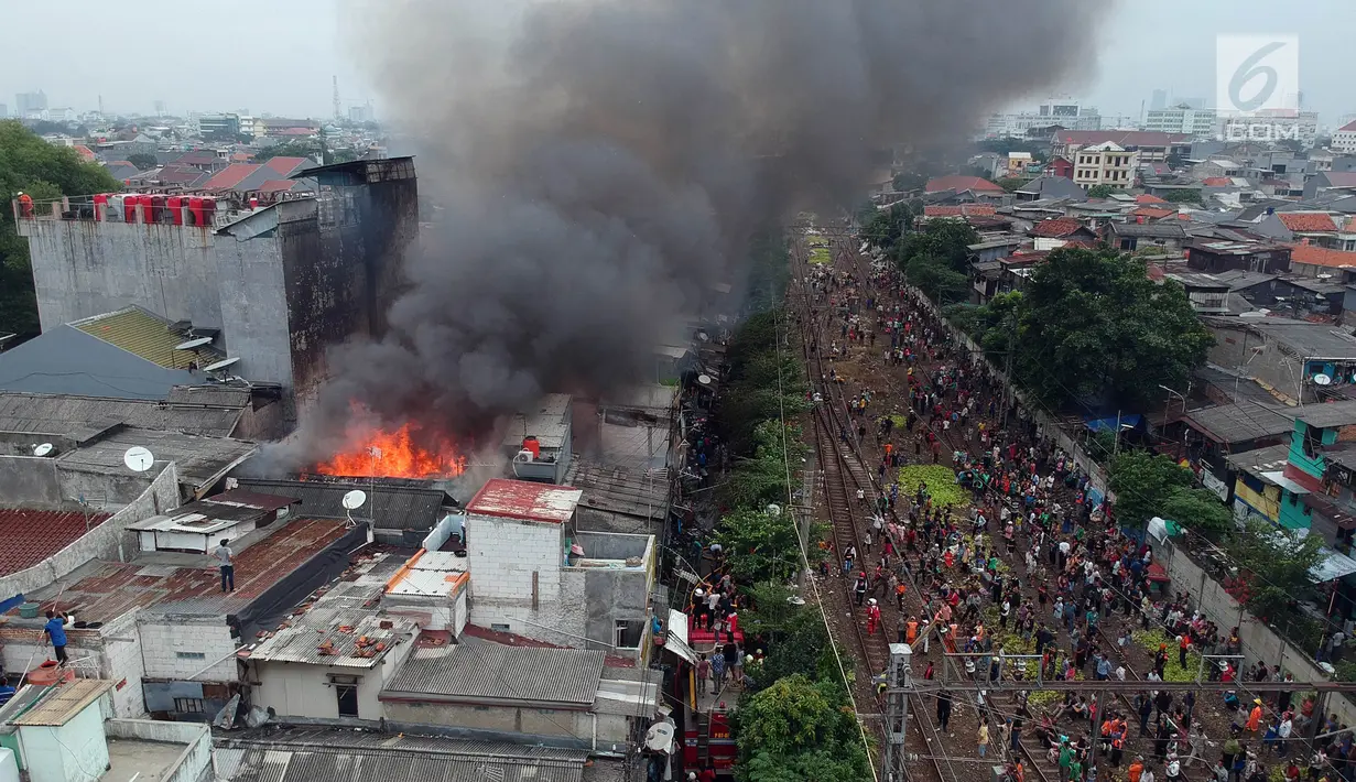 Foto udara kebakaran yang melanda permukiman padat penduduk di kawasan Tanah Tinggi, Johar Baru, Jakarta, Selasa (26/6). Kebakaran terjadi di rumah tinggal padat hunian di Jalan Tanah Tinggi 1 Johar Baru, Jakarta Pusat. (Liputan6.com/Arya Manggala)