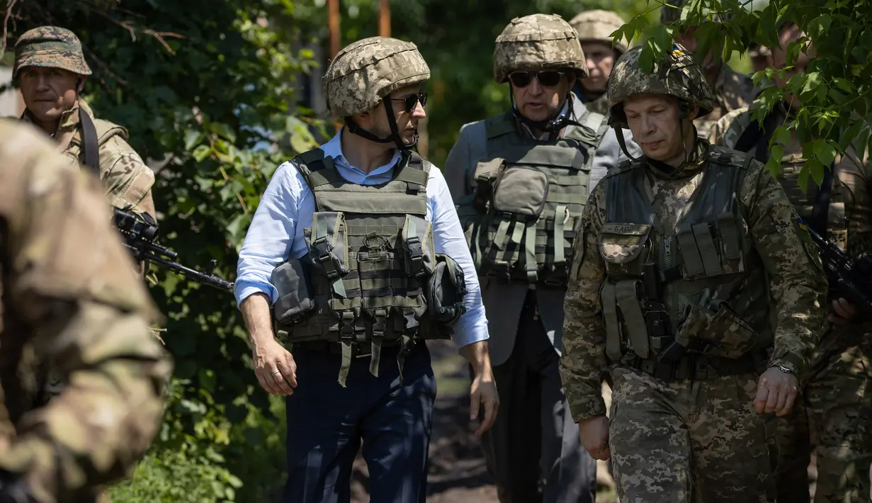 Presiden Ukraina Volodymyr Zelensky saat mengunjungi garis depan medan pertempuran dengan separatis pro-Rusia di Lugansk, Senin (27/5/2019). Zelenskiy mengenakan pakaian sipil, namun juga memakai helm militer dan rompi anti-peluru. (STR/UKRAINE PRESIDENTIAL PRESS SERVICE/AFP)