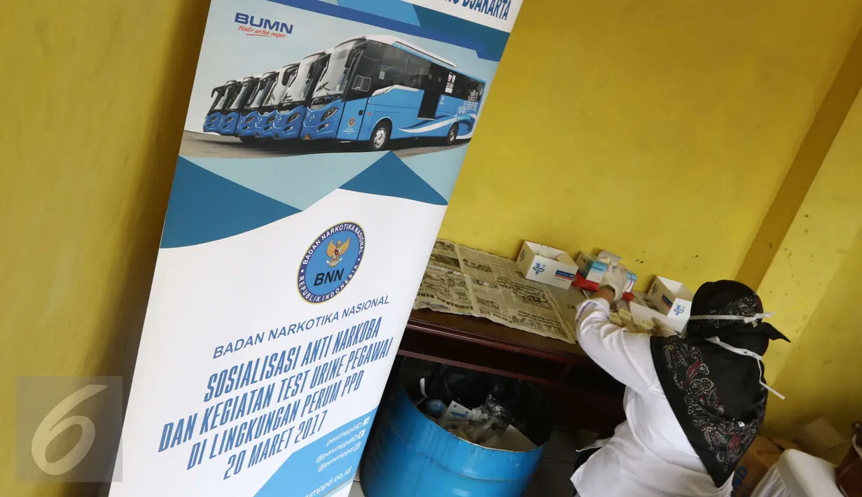 Seorang petugas sedang memproses tes urine di Pool Bus Perum PPD di Tangerang Selatan, Senin (20/3). Tes urine ini diikuti semua peserta yang terdiri dari direksi pejabat, staf dan pramudi/supir. (Liputan6.com/Helmi Afandi)