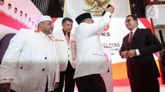 Presiden PKS Ahmad Syaikhu menyematkan peci kepada mantan Gubernur DKI Jakarta Anies Rasyid Baswedan (kanan) sebagai tanda dukungan sebagai bakal calon presiden 2024-2029 usai pembacaan hasil keputusan Musyawarah Majelis Syuro VIII PKS di Jakarta, Kamis (23/2/2023). PKS secara resmi mendukung Anies Baswedan sebagai bakal calon presiden tahun 2024-2029. (Liputan6.com/Johan Tallo)