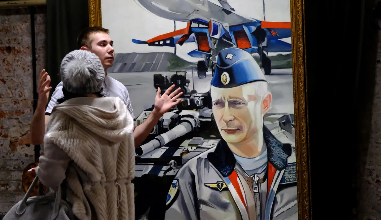 Dua orang pengunjung melihat lukisan yang bergambar Presiden Rusia Vladimir Putin dalam pameran Superputin di Museum Umam, Moskow (6/12). (AFP Photo/Yuri Kadobnov)